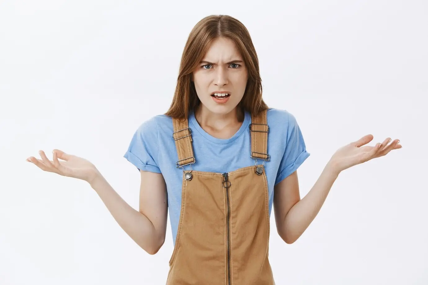 Раздосадованная и сердитая женщина пожимает плечами и спорит, не может понять, почему.